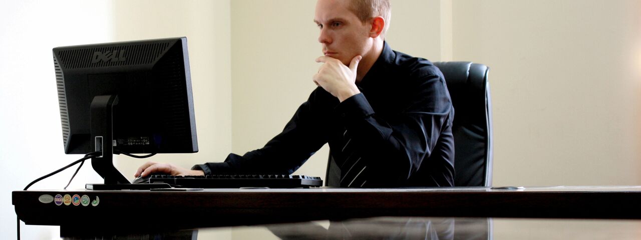 Concerned Business Man at Desk with Computer